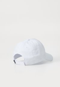 Casquette de baseball en coton blanche avec un bord incurvé, une sangle ajustable à l'arrière et des trous de ventilation brodés sur les côtés.