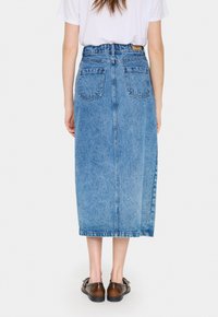Világoskék farmer maxi szoknya, egyenes szabásban, két hátsó zsebbel és márkázott bőr címkével a derékrésznél.