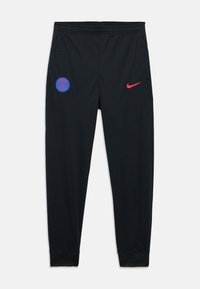 Pantalons de sport noirs à coupe slim, avec un logo PSG bleu et un swoosh Nike rouge. Fabriqués en matériau texturé et respirant.