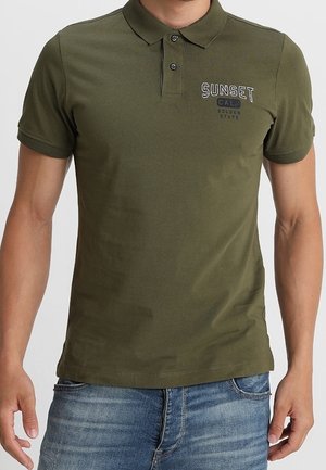 Polo vert olive en mélange de coton, avec une patte de boutonnage à trois boutons, des manches courtes, et un imprimé graphique "SUNSET CALI" sur la poitrine.