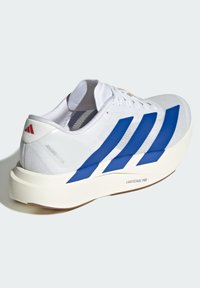 White athletic shoe featuring blue stripes, textured mesh upper, padded collar, and a thick white sole with "LIGHTSTRIKE PRO" branding.