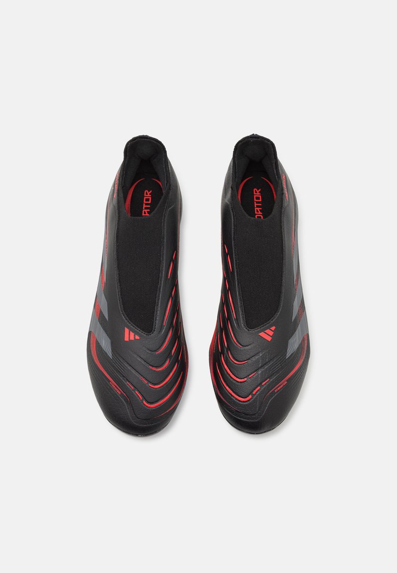 Botas de fútbol en negro y rojo con material sintético suave, diseño sin cordones y franjas rojas prominentes a lo largo de la superficie.