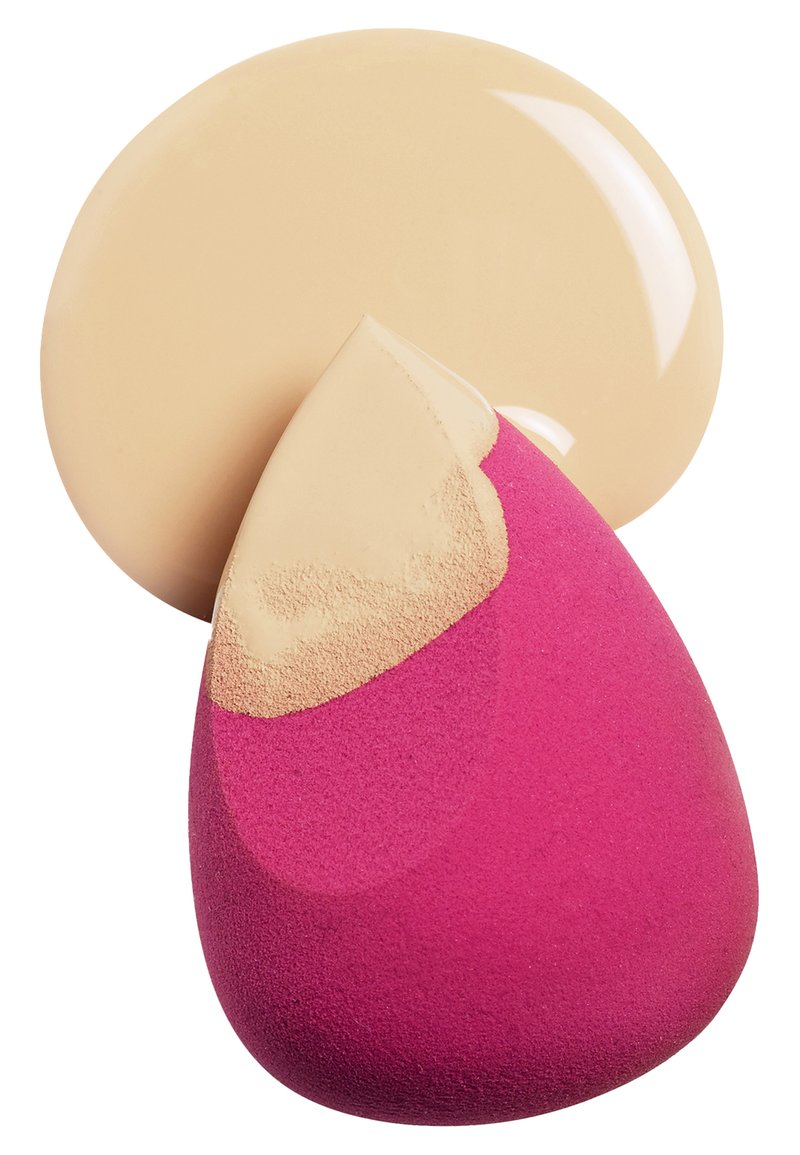 Esponja de maquillaje en forma de lágrima, rosa por un lado y beige por el otro. Una cucharada circular de base beige está cerca.