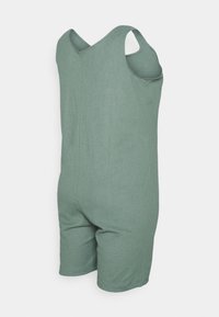 Grüner gerippter Stoff-Romper mit ärmellosem Design, ausgestattet mit einem gekreuzten Rücken und Shorts. Texturierte Oberfläche ohne zusätzliche Muster.