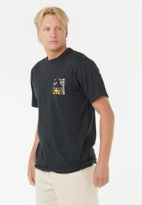 Schwarzes Baumwoll-T-Shirt mit kurzen Ärmeln, das ein grafisches Pocket-Design in weißen und gelben Wellen sowie abstrakten Formen auf der linken Brust trägt.