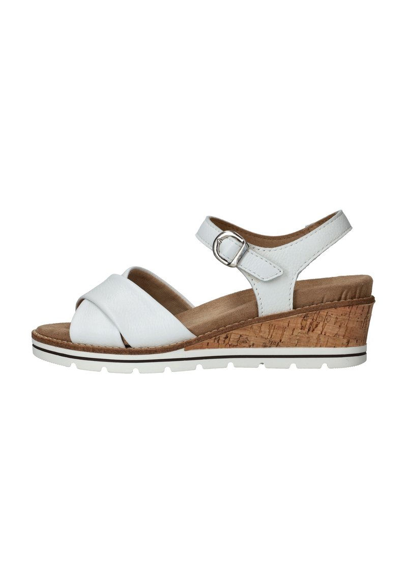 Sandalias blancas con un diseño de tiras entrecruzadas, correa ajustable en el tobillo, tacón de corcho y suela texturizada. Acabado en cuero suave.