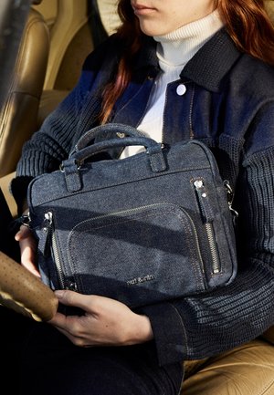 Denim handbag with dual top handles, zippered compartments, and stitching accents. Features a rectangular shape in dark blue fabric.