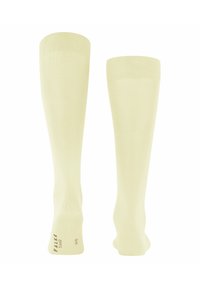 Kniestrümpfe in Hellgelb, aus glattem Stoff. Mit einem gerippten Oberteil und dezentem Branding an der Sohle.