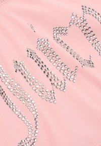 Tissu rose orné de strass métalliques formant un motif. Comprend des strass de tailles variées disposés en rangées et en motifs sur toute la surface.