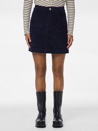 Μίνι φούστα από σκουρόχρωμο καρό με μπροστινή κουμπί, δύο πλαϊνές τσέπες και ίσια εφαρμογή, συνδυασμένη με μαύρες μπότες μέχρι το γόνατο.