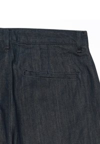 Pantalon en denim bleu foncé avec une unique poche arrière étroite et des passants de ceinture visibles à la taille.