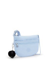 Borsa a spalla azzurro chiaro con tasca anteriore con zip e portachiavi a forma di scimmietta nera e pelosa attaccato alla fibbia della tracolla.