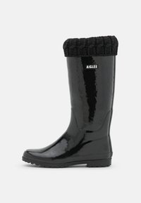 Botte de pluie en caoutchouc noir avec un revers tricoté noir, présentant une finition brillante et une semelle texturée pour une meilleure adhérence, avec un logo subtil.