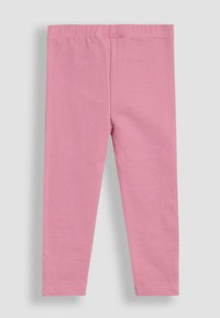 Egyszínű rózsaszín gyerek leggings, rugalmas derékpánttal, egy világos háttérrel szemben laposan elhelyezve.