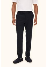 Navy nieformalna spodnie o gładkiej teksturze, z standardowym pasem i fasonem slim-fit, w połączeniu z ciemnymi loafersami.