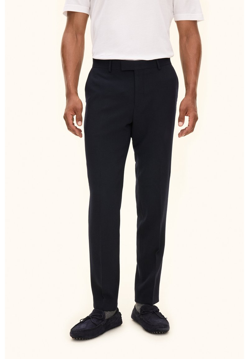 Navy nieformalna spodnie o gładkiej teksturze, z standardowym pasem i fasonem slim-fit, w połączeniu z ciemnymi loafersami.