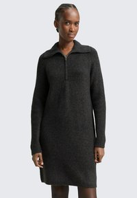 Czarna szara dzianinowa sukienka z kołnierzem na ćwierć zamek, długimi rękawami, prążkowaną fakturą i bocznymi rozcięciami, oferująca luźny krój.
