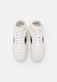 Baskets montantes en cuir blanc à finition lisse, ornées d'une bande brune et dorée sur le côté et de lacets blancs.