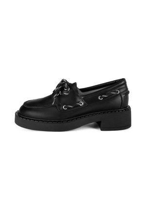 Zapato de cuero negro con puntera redondeada, detalles de cordones y ojales plateados. Presenta un tacón de plataforma grueso y texturizado.