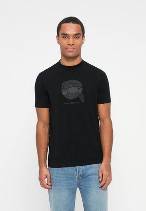 Czarny T-shirt z krótkim rękawem z szarym graficznym wzorem przedstawiającym głowę w okularach przeciwsłonecznych. Prosty design z mieszanki bawełny, z okrągłym dekoltem.