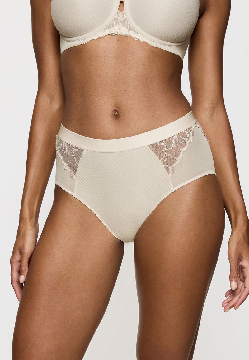 Panty beige a vita alta con un motivo testurizzato, pannelli laterali in pizzo e una cintura liscia, progettata per comfort e vestibilità.