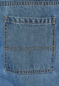 Denim tkanina u svijetloplavoj boji s jednim stražnjim džepom. Vidljivi šavovi u kontrastnoj narančastoj boji duž rubova i linija džepova.