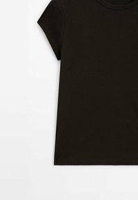 T-shirt nera a maniche corte realizzata in morbido cotone. Presenta un colletto rotondo e un taglio dritto, con una texture liscia e senza motivi visibili.