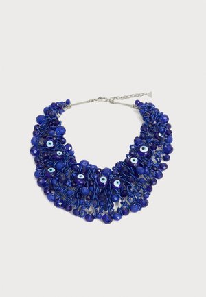 Halskæde med flere snore af små og store mørkeblå perler, med flere blå onde øje-vedhæng og en sølv-lås og kædeforlænger.