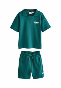 Tyrkysový bavlnený športový set, ktorý obsahuje polokošeľu s krátkym rukávom a golierom a zodpovedajúce šortky. Šortky majú elastický pás a bočné vrecká.