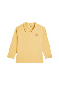 Keltainen pitkähihaisen polo-paita, joka on valmistettu pehmeästä puuvillasta ja jossa on kaulus. Paidassa on brodeerattu kuvio vasemmassa rintataskussa.