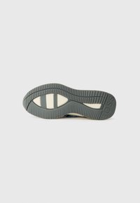 Shoe sole with a gray rubber base, textured pattern, cream-colored accents, and a branded section reading "BOSS." Curved shape with ridges.