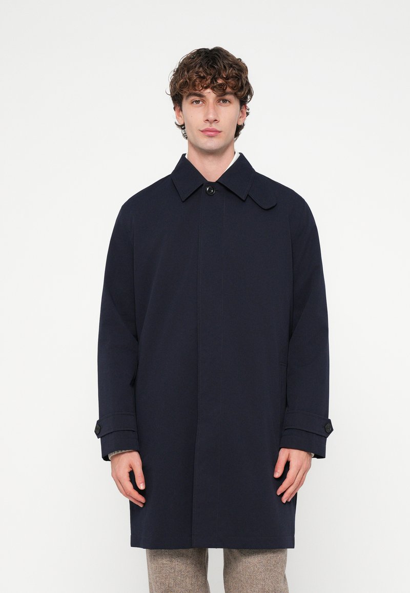 Tmavomodrý trenčkot so širokým golierom, zapínaním na gombíky vpredu a bočnými vreckami. Má priliehavý strih a hladkú textúru.