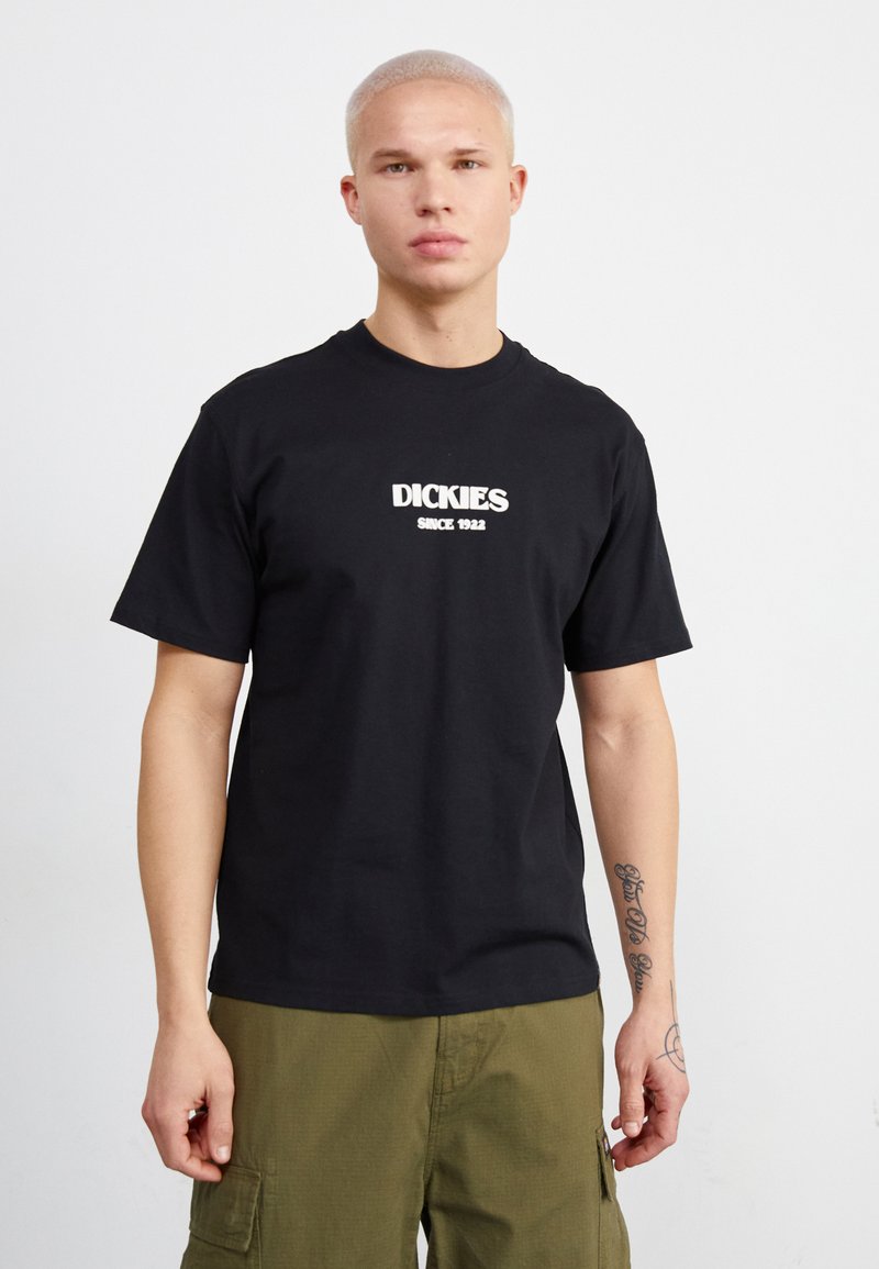Camiseta de algodón negra con un logo blanco de "DICKIES" y el texto "DESDE 1922" en un ajuste simple y relajado con mangas cortas.