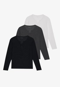 Tre langærmede henley skjorter i sort, grå og hvid. Hver har en knappet stolpe og blødt tekstureret stof.