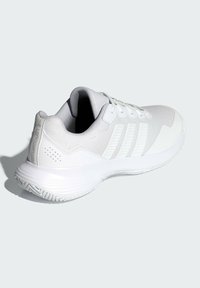 Biely športový topánok s pleteným zvrškom, textúrovanými prekrytiami a tromi pruhovanými akcentmi. Hladká gumová podrážka s trakčným vzorom.