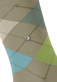 Skarpetki w beżowym, zielonym i niebieskim wzorze. Posiadają kształty rombów, fakturowany materiał i zielone przeszycie. Zawierają akcent w postaci srebrnego logo.