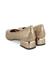 Chaussures dorées texturées et tissées avec un petit talon carré, présentant un accent métallique brillant au niveau du talon et une doublure intérieure lisse.