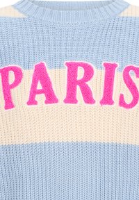 Sweter dzianinowy w jasnoniebieskie i kremowe paski, z wyraźnym różowym napisem "PARIS" o teksturowanym, puszystym wykończeniu. Okrągły dekolt.