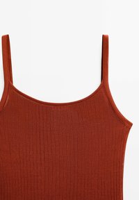 Rippentop in Rostfarbe mit dünnen Spaghettiträgern und einem runden Ausschnitt. Hergestellt aus einem weichen Textil, mit vertikalen Strukturstreifen.