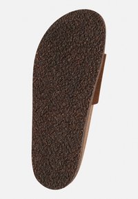 Bruine, gestructureerde inlegzool met een ruwe oppervlakte, voorzien van een gladde, bruine rand en een ronde neus. Ontworpen voor comfort en voetondersteuning.