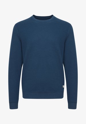 Sötétkék pulóver texturált anyagból, kerek nyakkivágással, hosszú ujjakkal, bordázott mandzsettákkal és alján. Kis logós cimke az alsó bal oldalon.