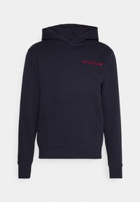 Marineblaue Kapuzenjacke aus weichem Stoff mit einer Kängurutasche. Mit rotem "HILFIGER"-Text auf der Brust sowie gerippten Bündchen und Saum.
