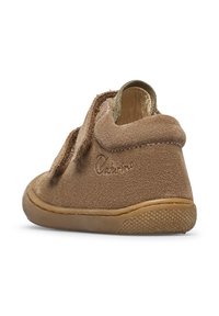 Hnědá semišová dětská bota s kulatou špičkou, suchým zipem a texturovanou gumovou podrážkou. Disponuje měkkou podšívkou a jemným logem.