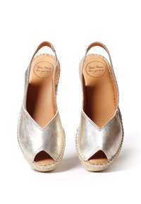 Espadrillas di metallo oro con punta aperta, design slingback e suola avvolta in juta. Texture liscia e dettagli di cucitura minimal.