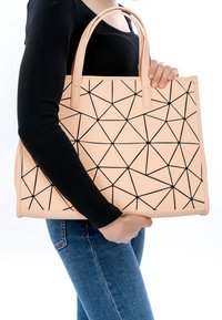 Borsa a mano color pesca con pattern geometrico nero, materiale sintetico liscio, doppie maniglie, forma rettangolare e dettagli di cucitura visibili.