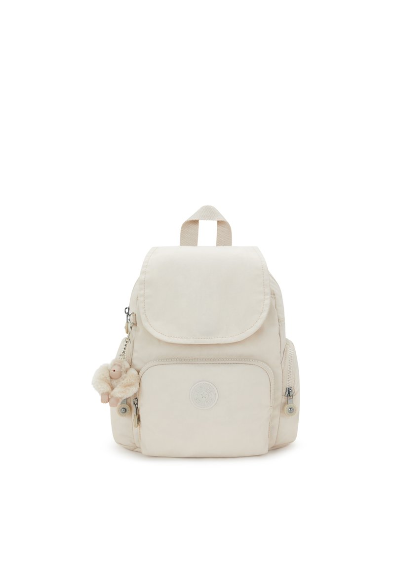 Mochila de color crema con cierre de solapa, bolsillo delantero con cremallera y bolsillos laterales. Presenta un suave llavero de mono de peluche como acento.