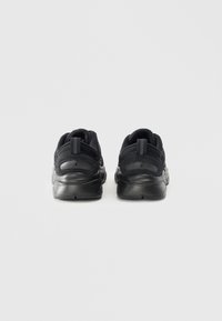 Par crnih atletskih tenisica prikazanih s leđa, izrađenih od mrežastih i kožnih materijala s trakama za povlačenje na bijeloj pozadini.