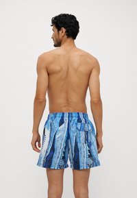 Men's swim trunks featuring a blue abstract pattern. Made from lightweight material, with an elastic waistband and a back pocket.