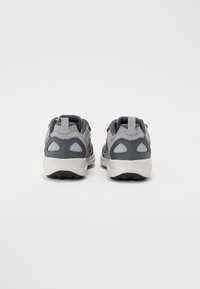 Gray athletic shoes with a cushioned sole, mesh fabric upper, contrasting dark accents, and a pull tab on the heel for easy wear.