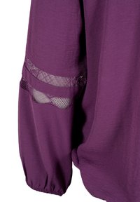 Vêtement à manches longues violet avec deux panneaux horizontaux en dentelle filetée sur le haut du bras et un poignet élastique froncé.